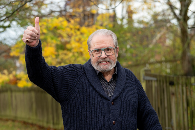 Image of man stood outside with his fist in the air